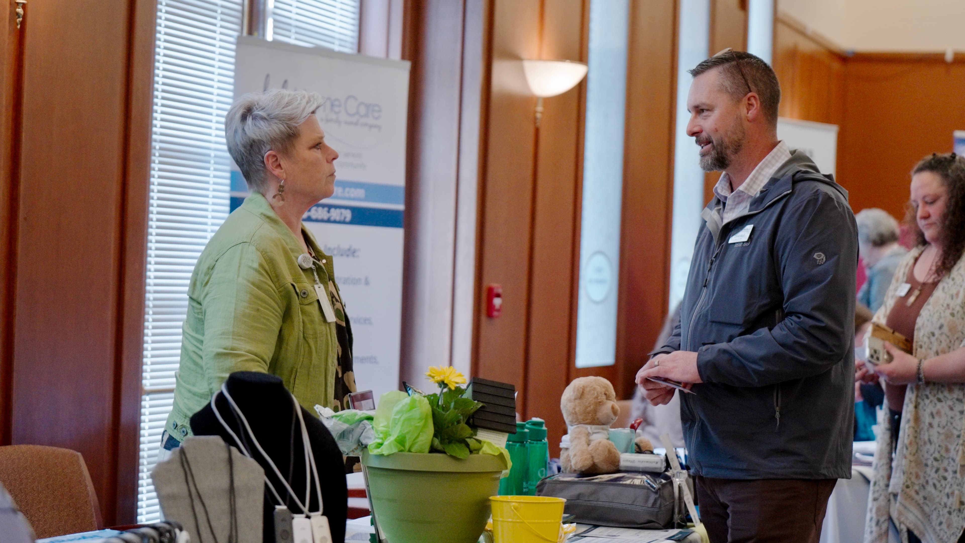 Two attendees networking at a vendor exhibitor booth